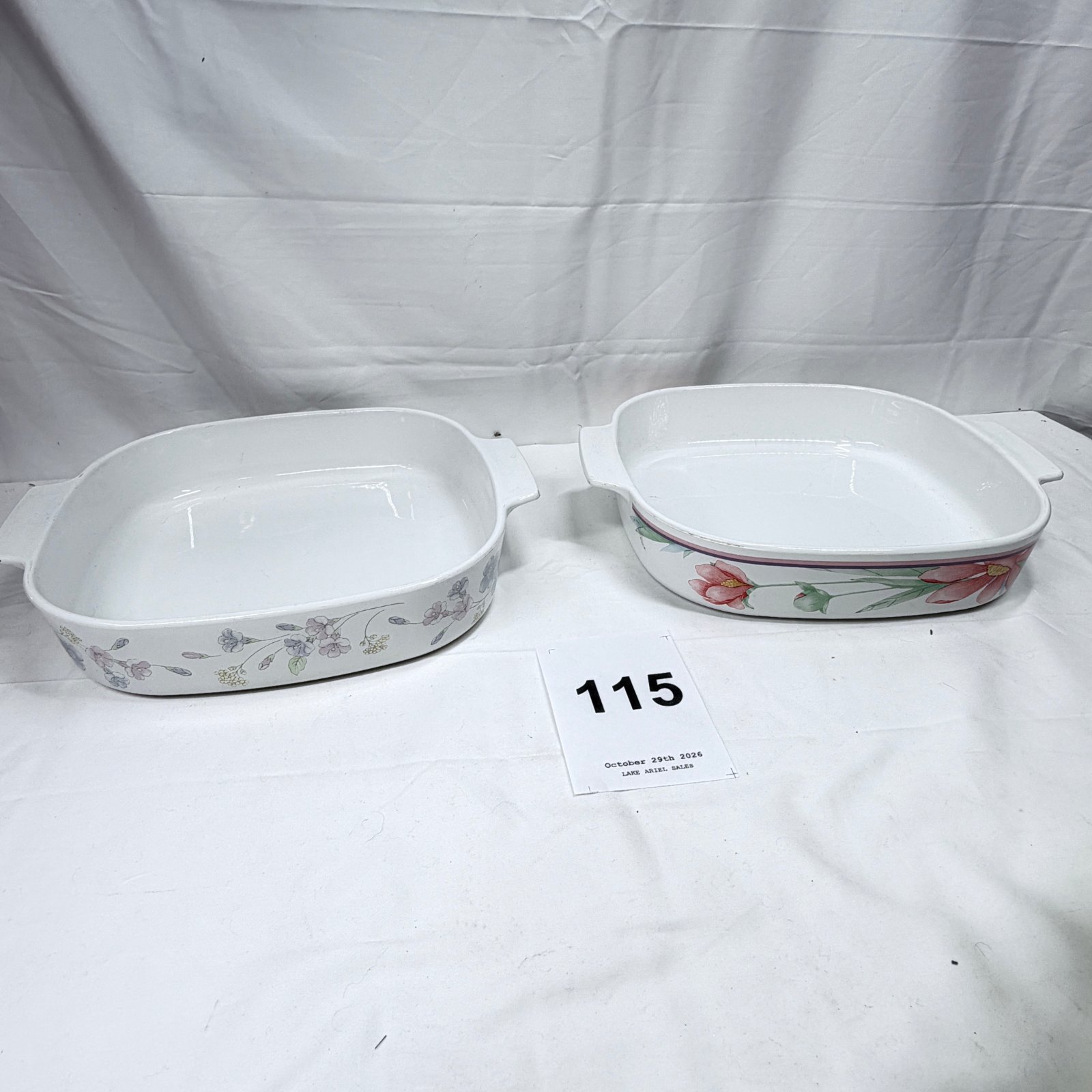 Lot 115: Pair of floral ceramic oven-to-table casserole dishes with handles, pink/blue floral pattern bakeware