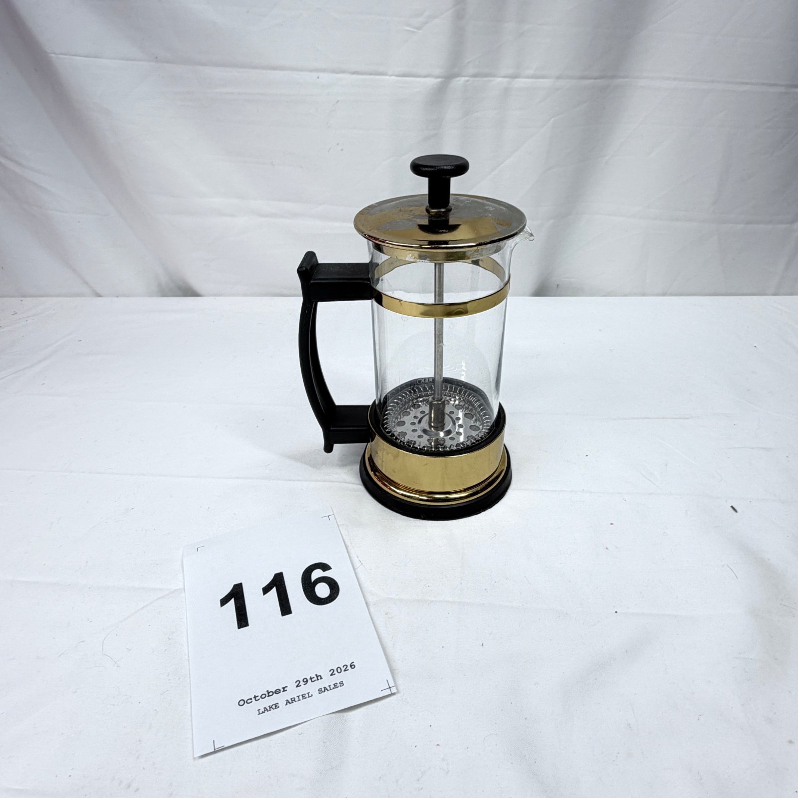 Lot 116: Gold-tone and glass French press coffee maker with black handle and plunger