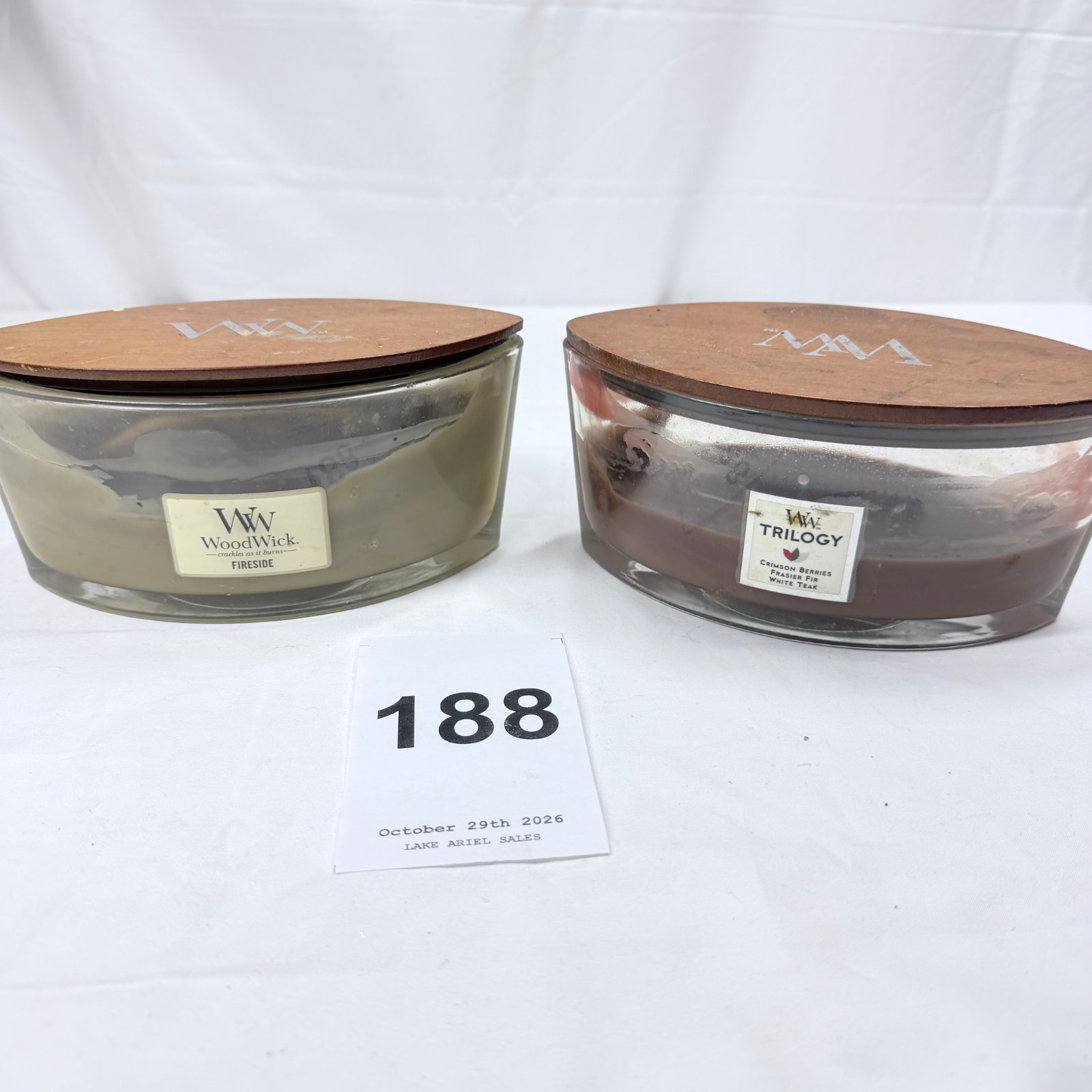 Lot 188: WoodWick "Fireside" and Trilogy "Crimson Berries, Frasier Fir, White Teak" ellipse jar candles, set of 2