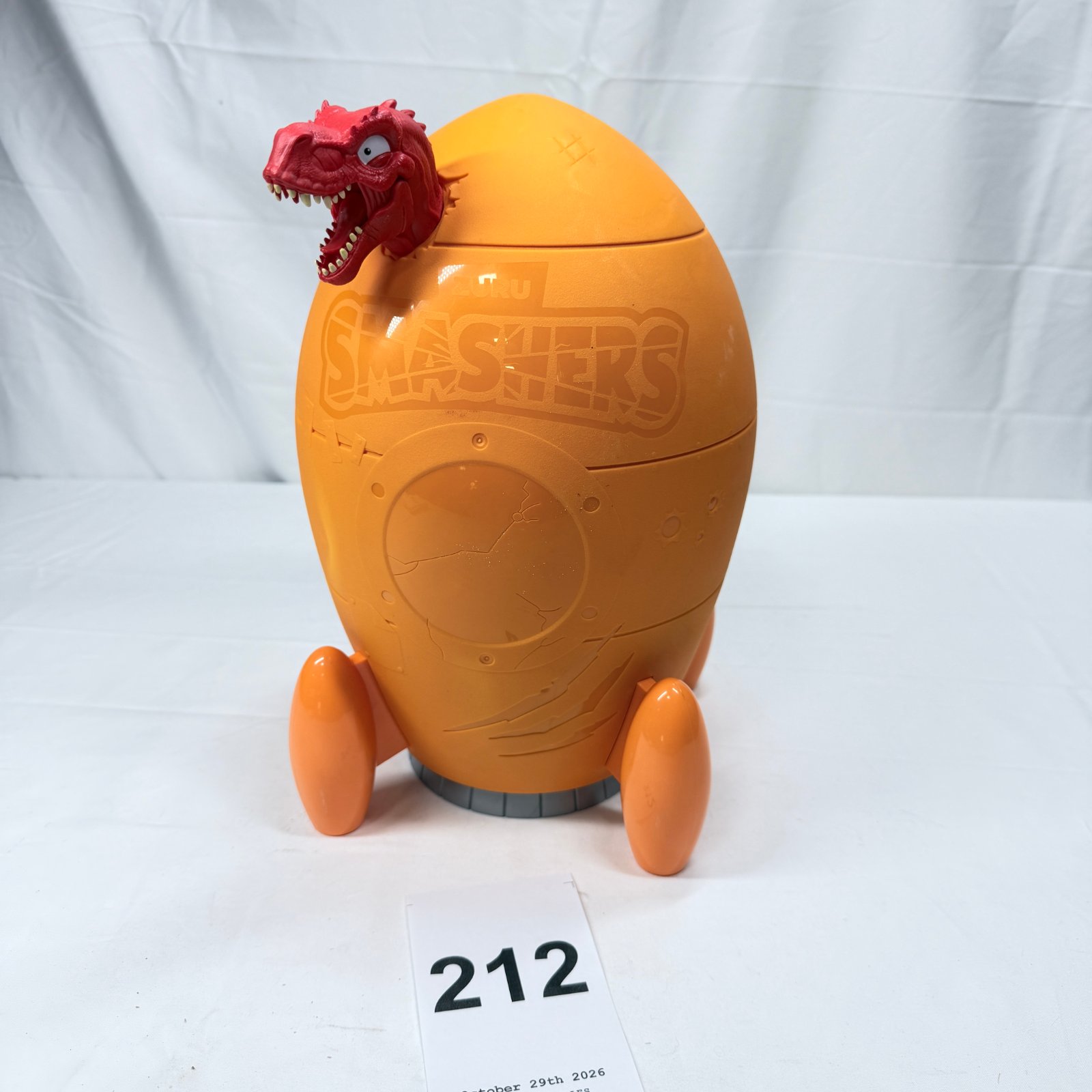 Lot 212: Zuru Smashers T-Rex dinosaur egg playset with mini surprise eggs and figures, orange rocket-shaped case