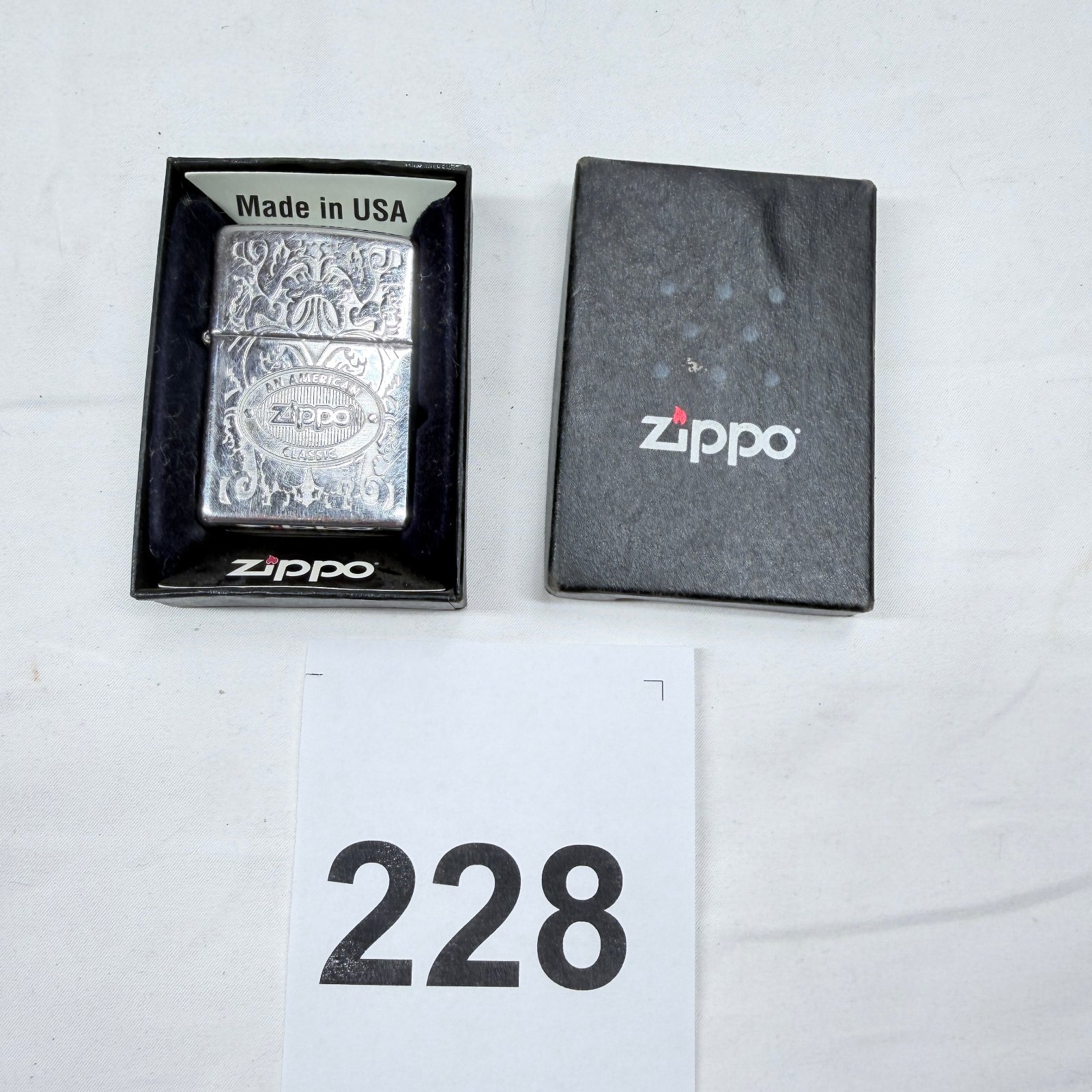 Lot 228: Zippo "An American Classic" brushed chrome ornate scroll pattern pocket lighter, with box used