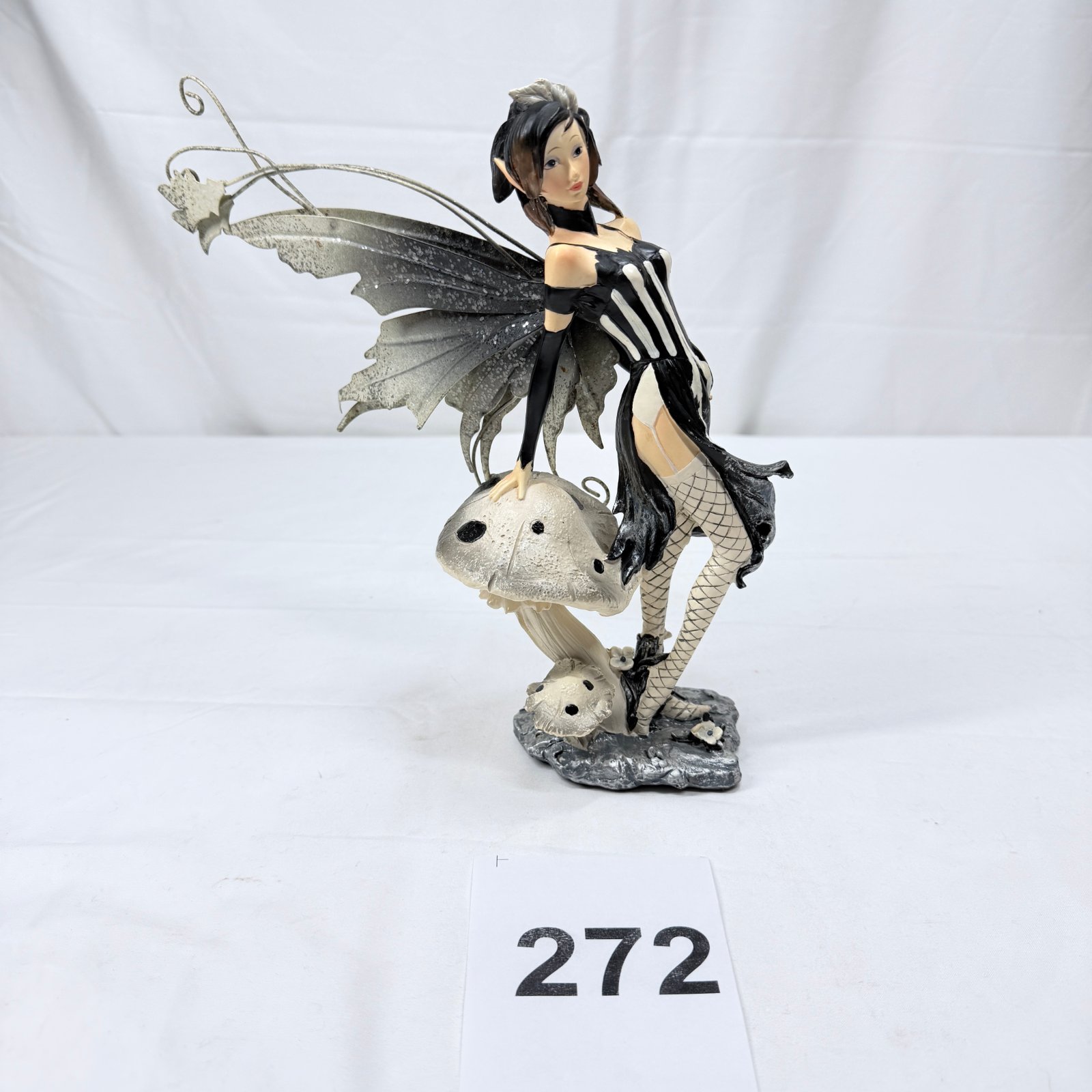 Lot 272: Gothic skeleton-dress fairy resin figurine with metal wings, perched on mushrooms