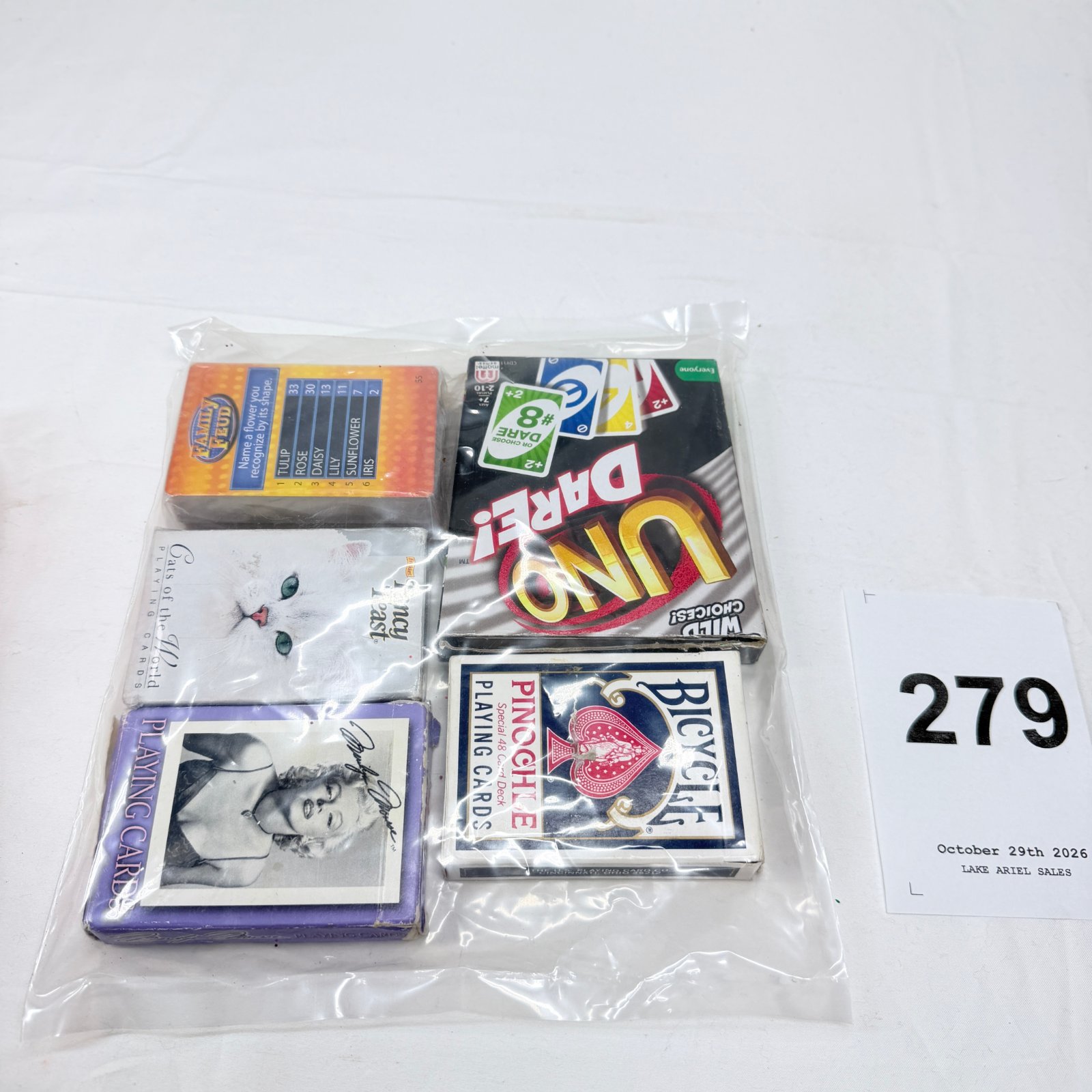 Lot 279: Lot of 6 playing card decks: Family Feud, UNO Dare, Fancy Feast Cats of the World, Marilyn Monroe, Bicycle Pinochle