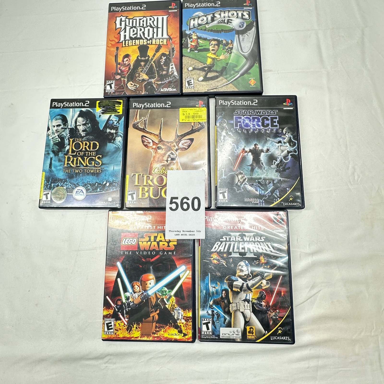 Lot 560: PS2 game lot of 7: Guitar Hero III, Hot Shots Golf 3, LOTR Two Towers, Cabela's Trophy Bucks, Star Wars Force Unleashed, LEGO Star Wars, Battlefront II