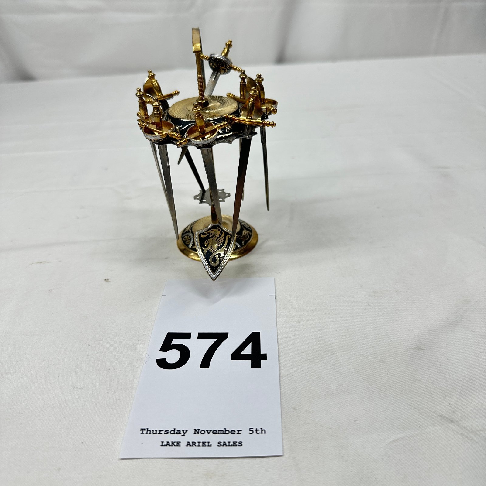 Lot 574: Spanish Toledo damascene gold-tone miniature sword display stand, dragon shield base, Made in Spain