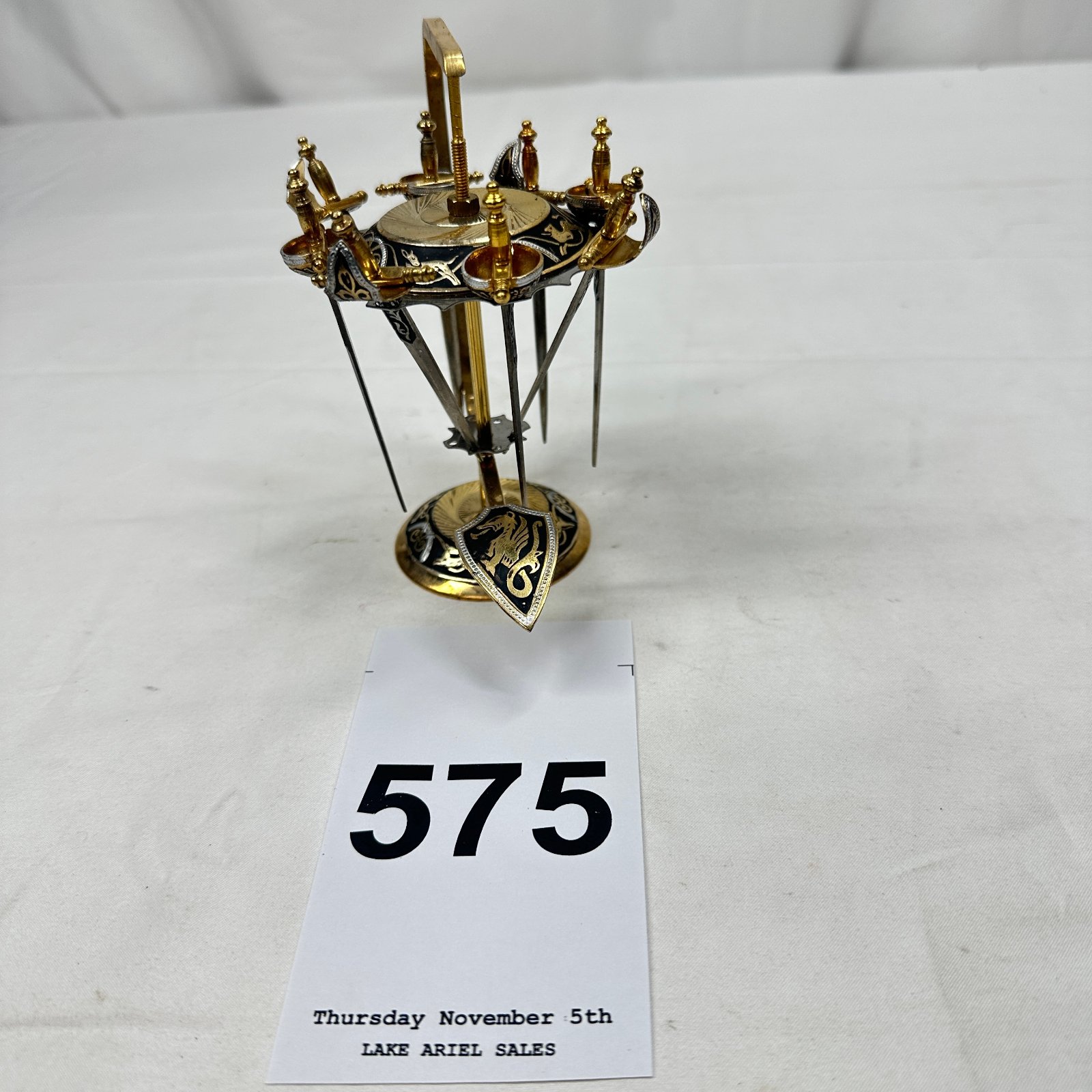 Lot 575: Spanish Toledo damascene gold-inlaid miniature sword stand with shield, umbrella rack form, 6-sword set