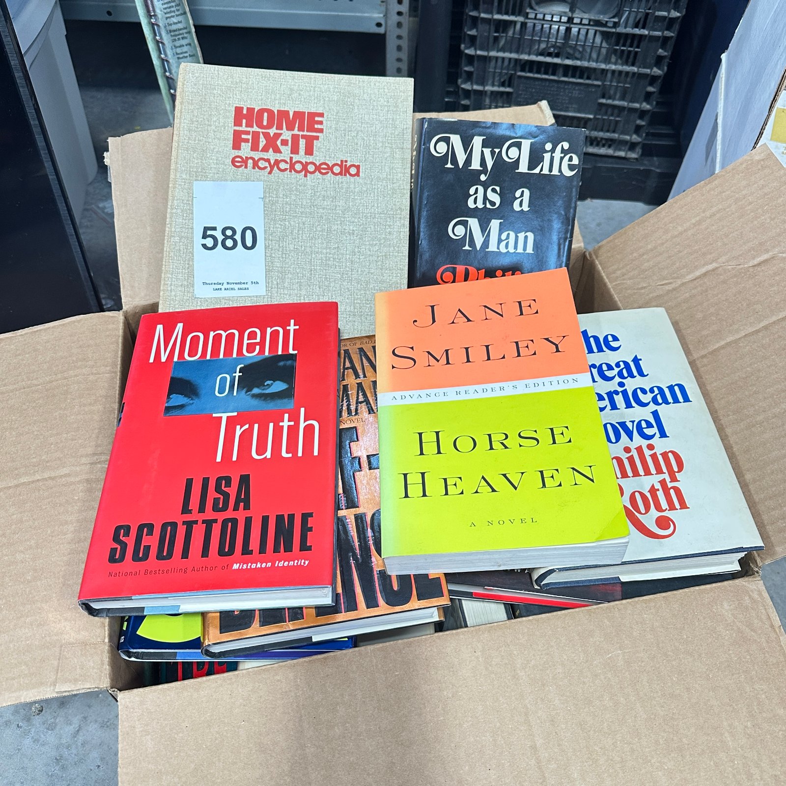 Lot 580: Box lot of bestseller hardcover/paperback novels: Philip Roth, Jane Smiley, Lisa Scottoline, Janet Evanovich, Jonathan Kellerman, Robert Ludlum, plus Home Fix-It Encyclopedia