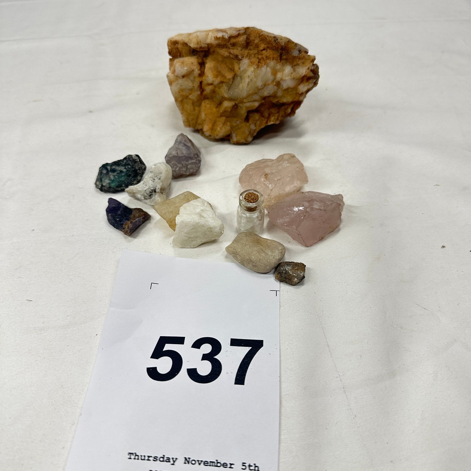 Lot 537: Raw mineral specimen lot: rose quartz, amethyst, apatite, and quartz chip vial, with quartz crystal matrix