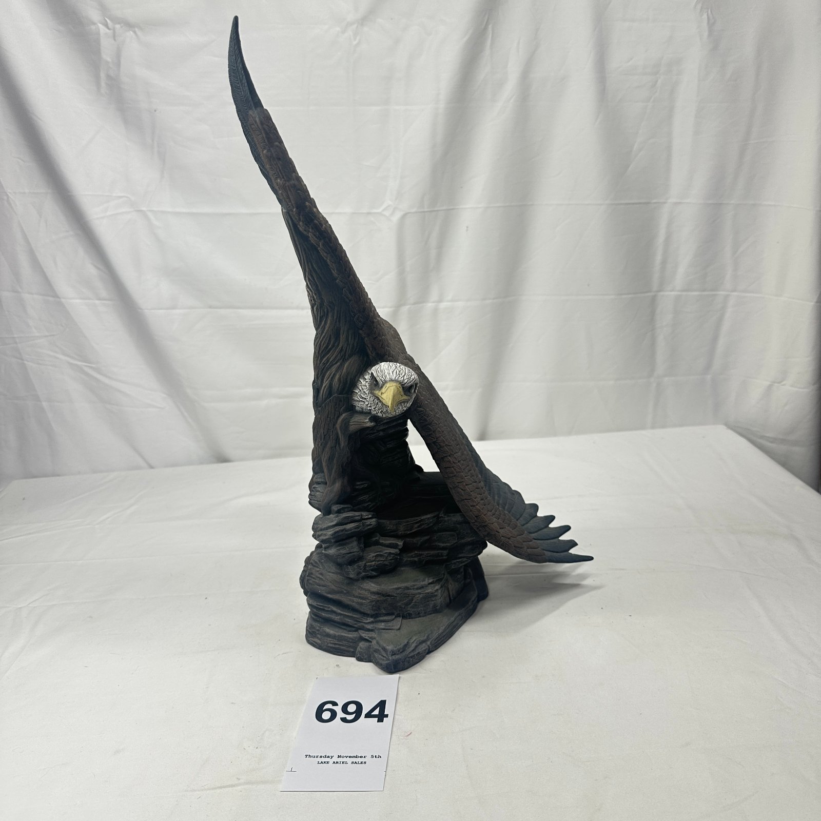 Lot 694: Bald eagle wings-spread plaster sculpture on rock base, wildlife figurine