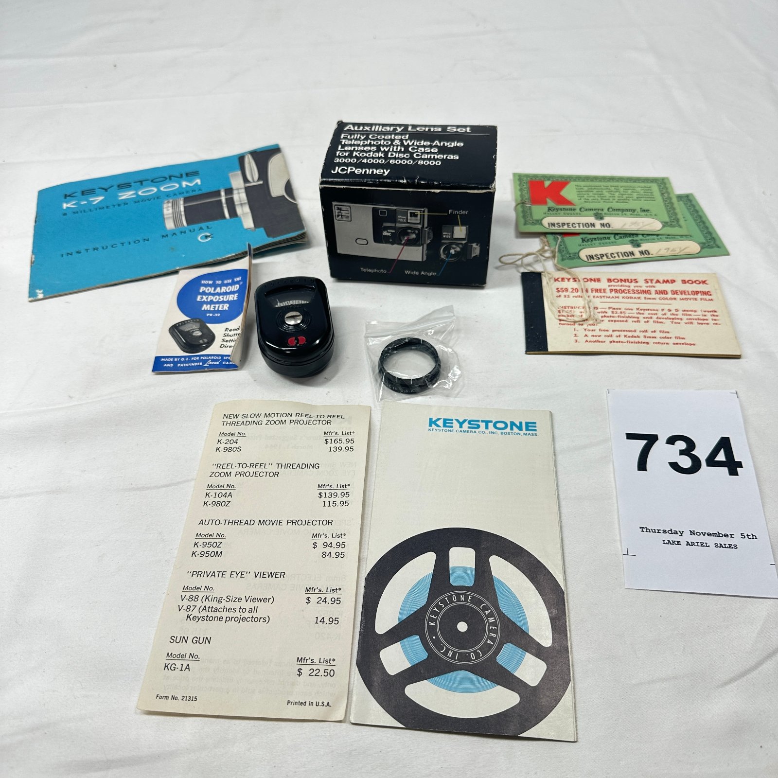 Lot 734: Keystone Camera Co. 8mm movie camera accessory lot: K-7 Zoom manual, JCPenney auxiliary lens set, Polaroid PR-22 exposure meter, P&D stamp book