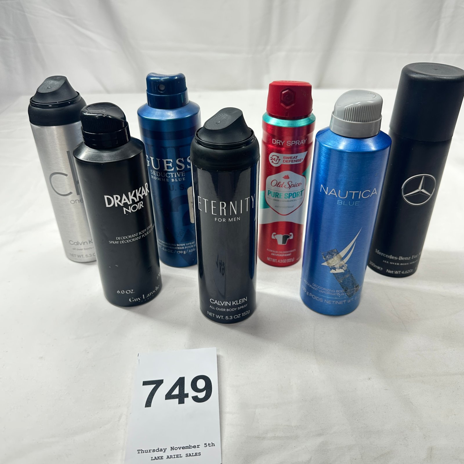 Lot 749: Men's partial body spray lot (7): Calvin Klein CK One, Drakkar Noir, Guess Seductive Homme Blue, Calvin Klein Eternity, Old Spice Pure Sport, Nautica Blue, Mercedes-Benz