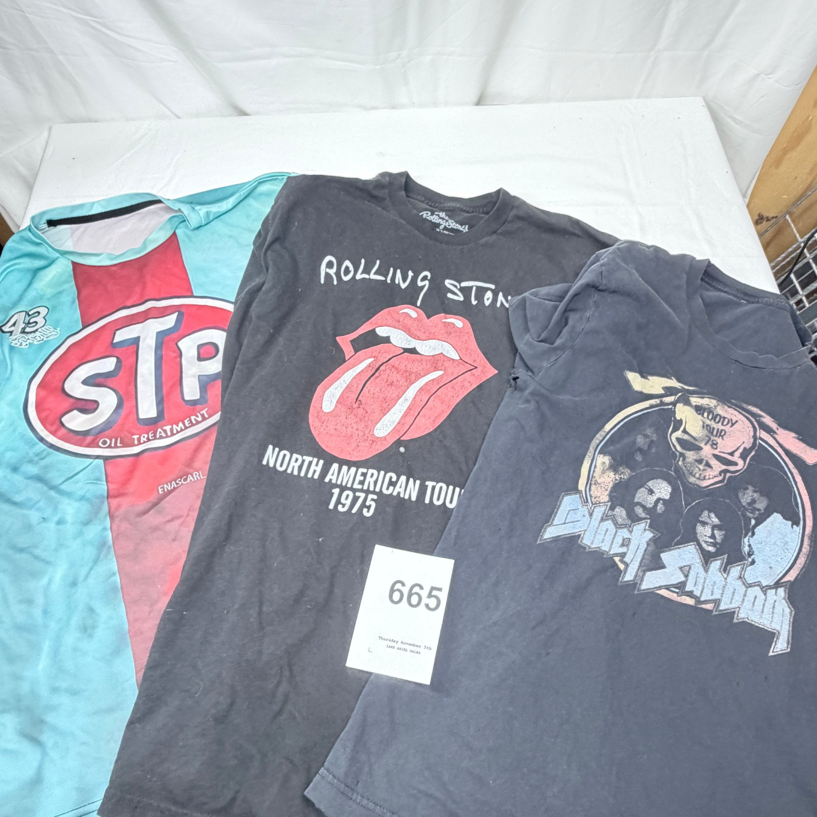 Lot 665: Lot of 3 band/racing graphic T-shirts: Rolling Stones "North American Tour 1975", Quiet Riot, and STP Oil Treatment tee, size L