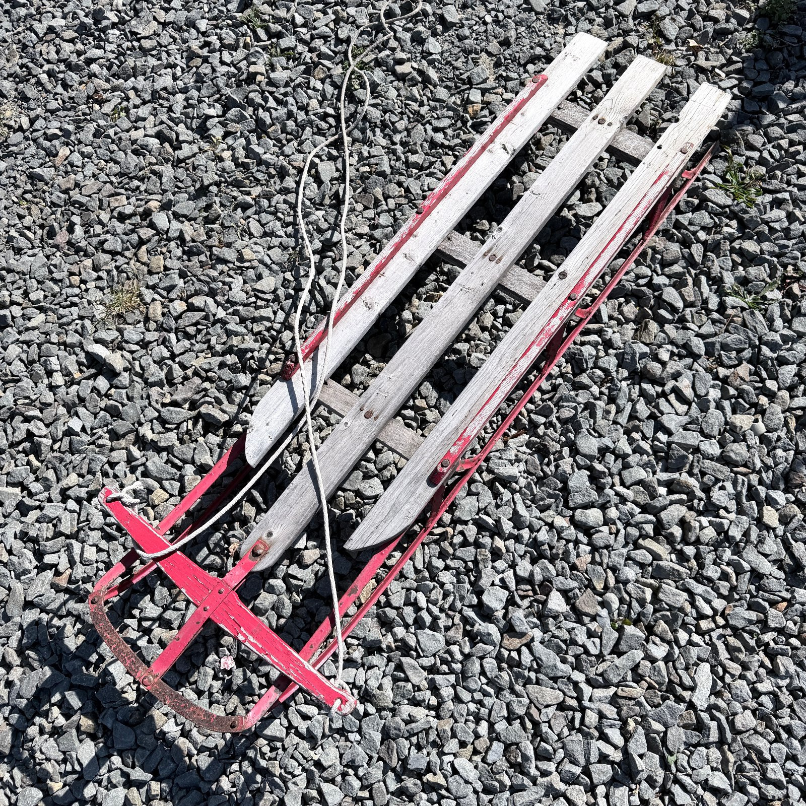 Lot 817: Vintage wooden slat and steel runner children's sled, red-painted frame with pull rope