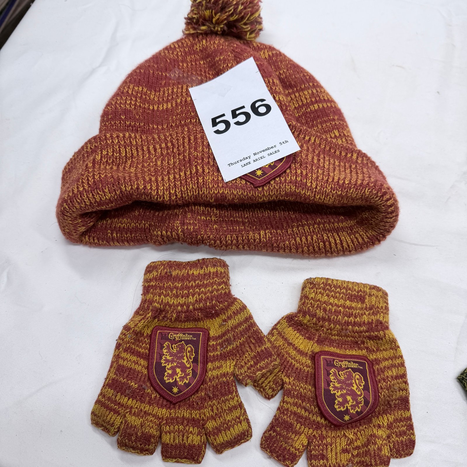 Lot 556: Harry Potter Gryffindor knit beanie hat and fingerless gloves set, pom-pom hat with house crest patches