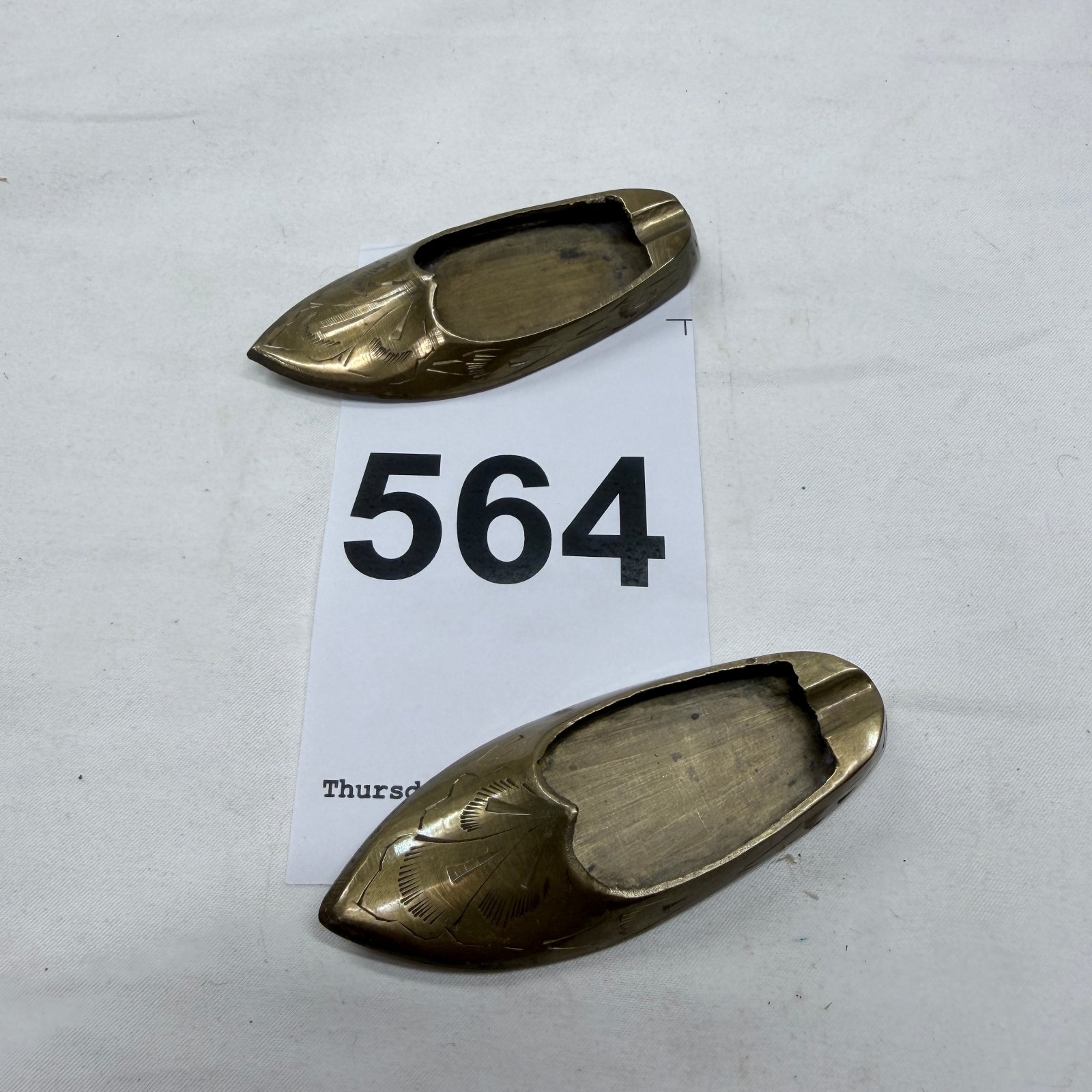 Lot 564: Brass engraved slipper-shaped ashtrays, hand-etched Indian curved toe design, set of two
