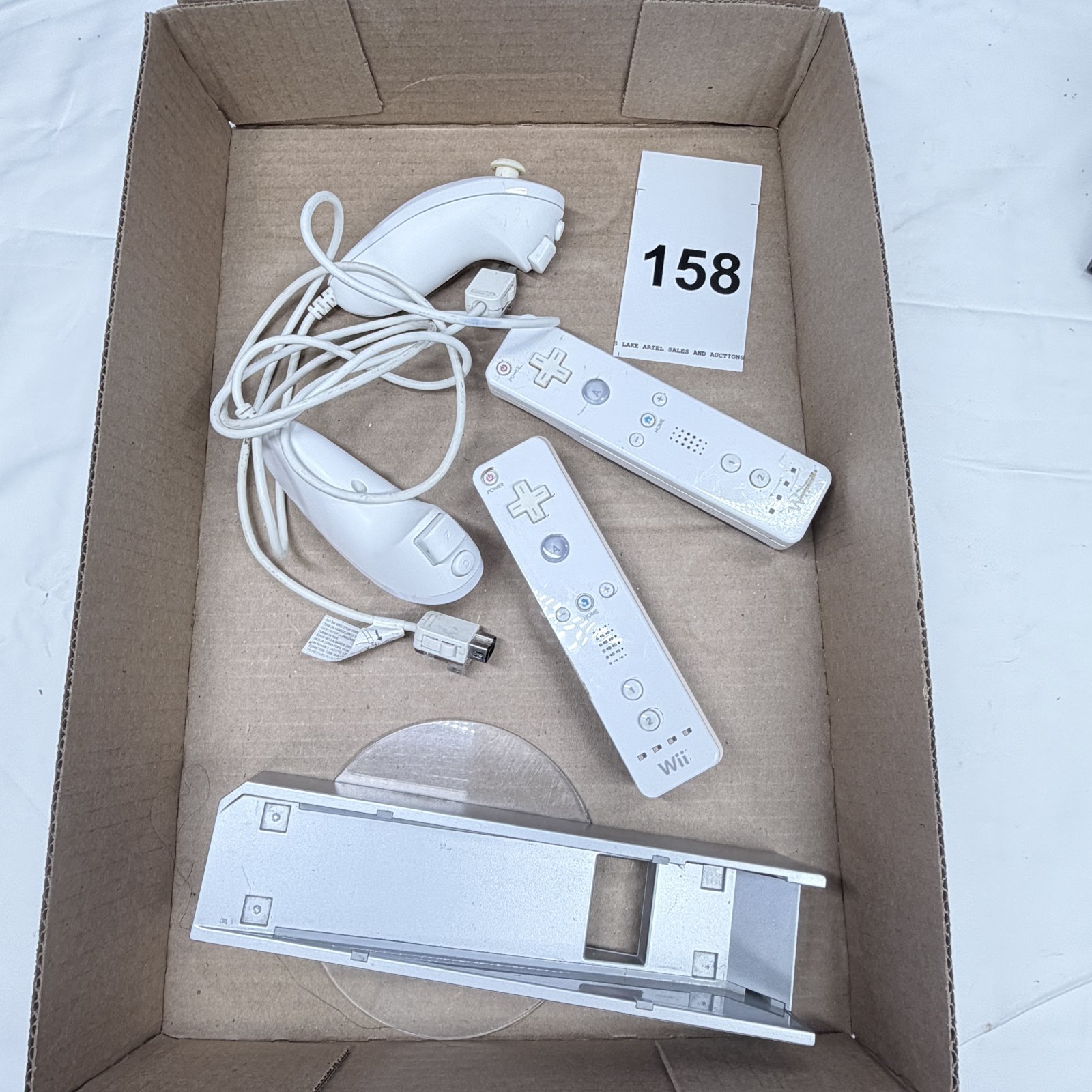 Lot 158: Nintendo Wii remotes, Nunchuk, and sensor bar with Energizer charging batteries, controller accessory lot
