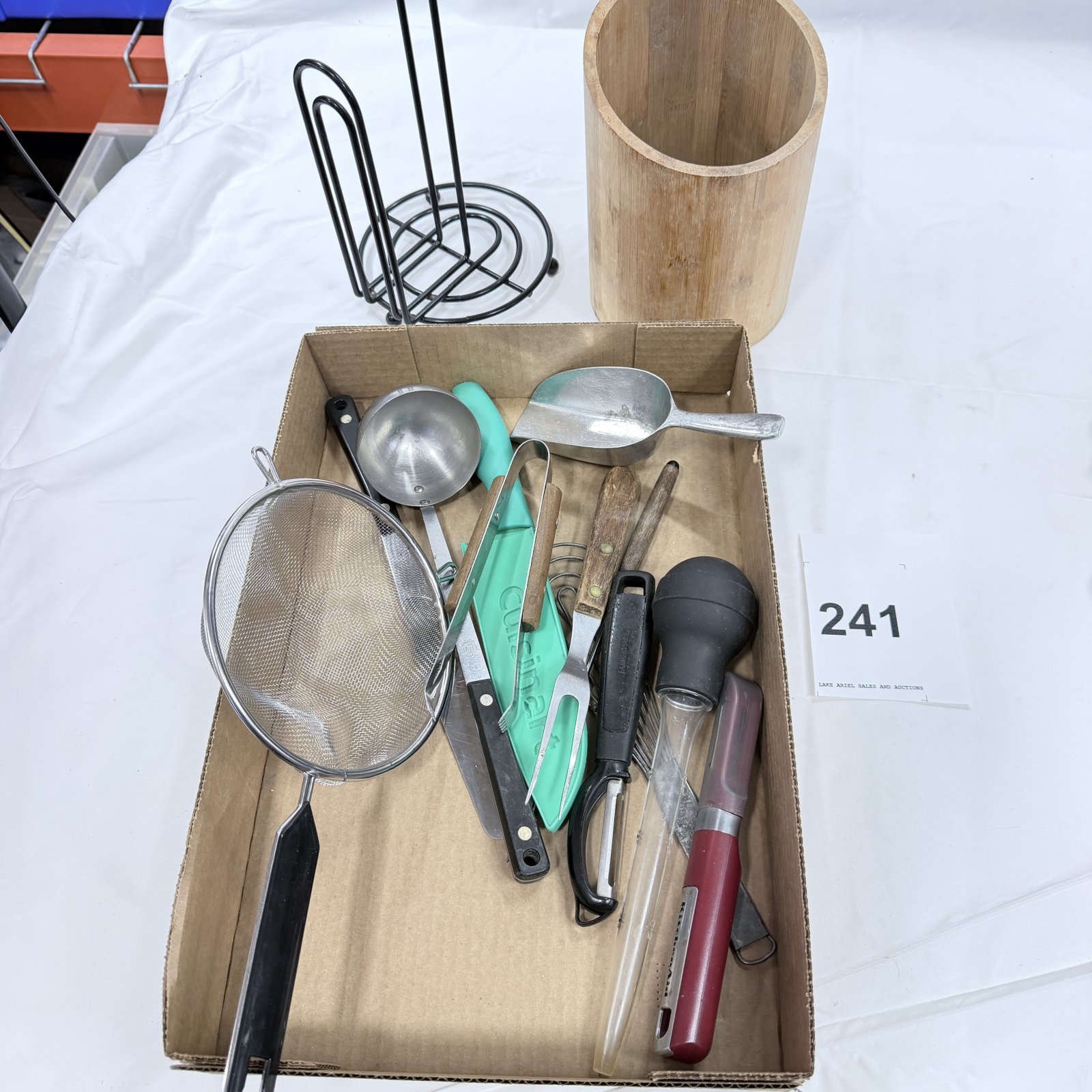 Lot 241: Kitchen utensil lot: Cuisinart chef's knife, KitchenAid baster, Farberware meat fork/tenderizer, wire whisk, strainer, ladle, scoop; with bamboo utensil holder and wire napkin holder