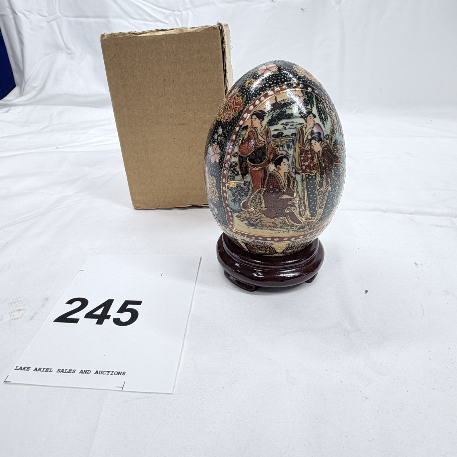 Lot 245: Satsuma-style decorated egg with geisha figures, on wooden stand, Japanese decorative egg