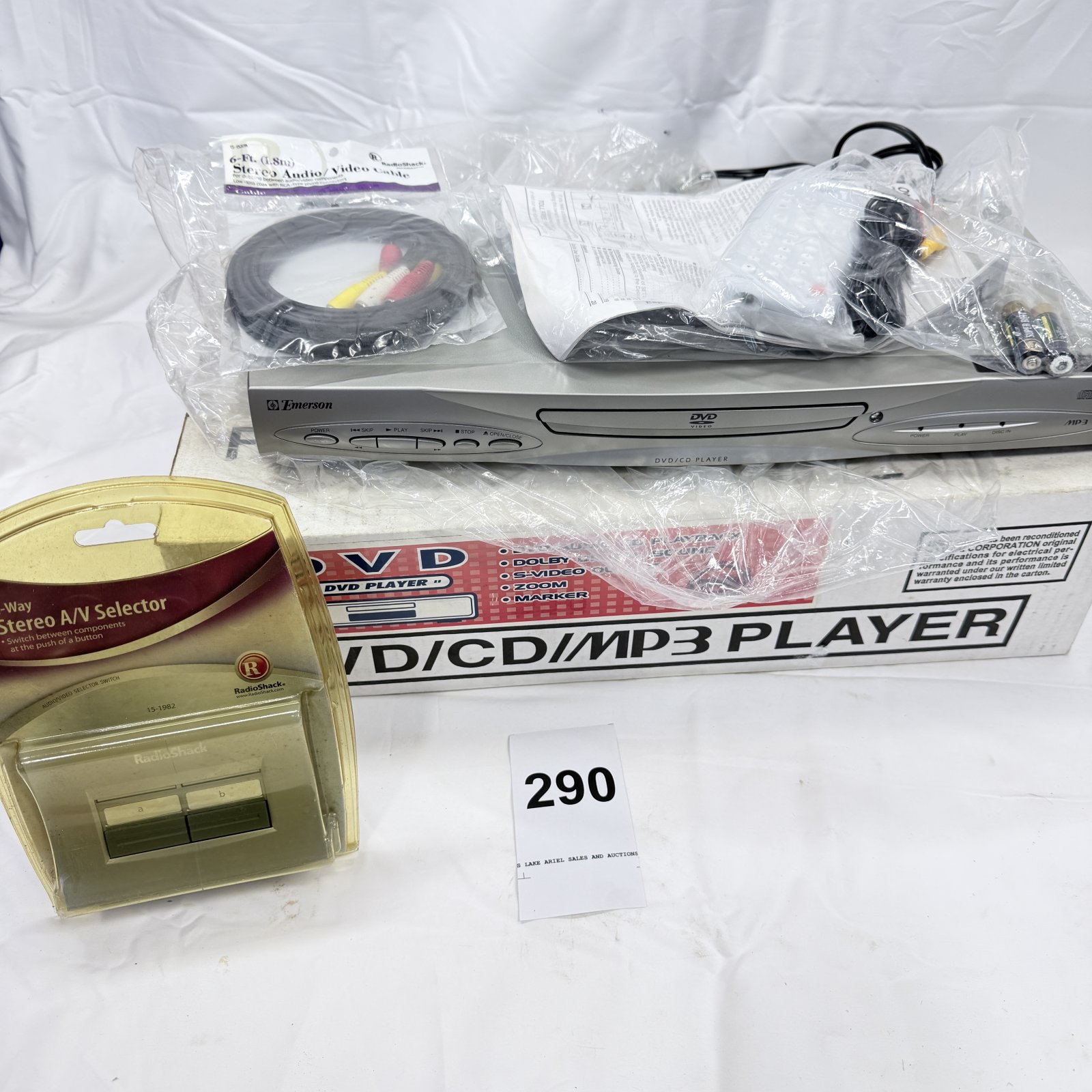 Lot 290: Emerson EWD7004 DVD/CD/MP3 Player with remote, cables & RadioShack A/V selector switch, in original box