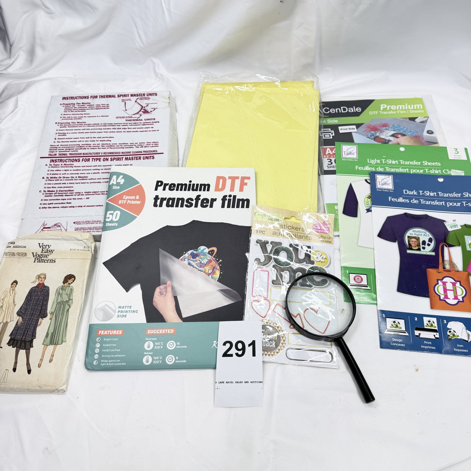 Lot 291: Craft supply lot: DTF transfer film, June Tailor T-Shirt Transfer Sheets, CenDale DTF sheets, Vogue 7149 sewing pattern, stickers & magnifier