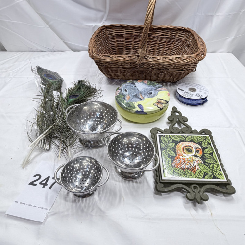 Lot 247: Wicker Basket, Peacock Feathers, Metal Colanders, Owl Decor Plates & Trivet Lot