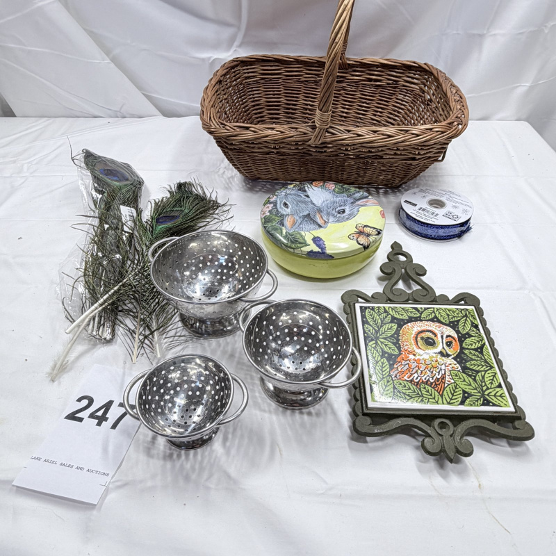 Lot 247: Wicker Basket, Peacock Feathers, Metal Colanders, Owl Decor Plates & Trivet Lot