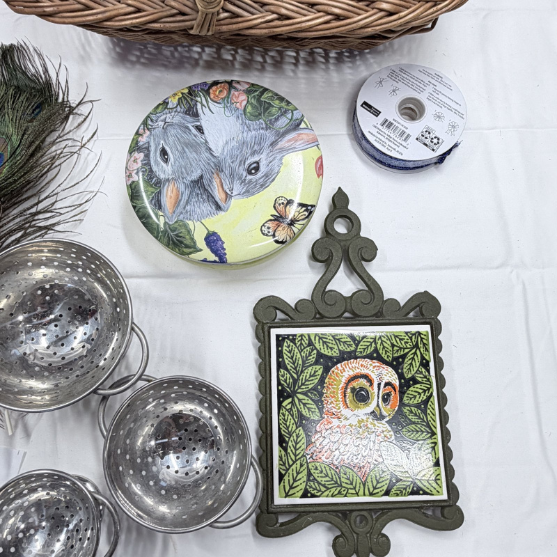 Lot 247: Wicker Basket, Peacock Feathers, Metal Colanders, Owl Decor Plates & Trivet Lot