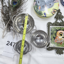 Lot 247: Wicker Basket, Peacock Feathers, Metal Colanders, Owl Decor Plates & Trivet Lot