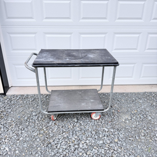 Lot 647: Vintage industrial two-tier rolling utility cart, steel frame with rubber-topped shelves on locking casters
