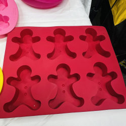 Lot 416: Wilton silicone bakeware lot: "Tulips & Daisies" flower molds, gingerbread man molds, and deviled egg trays, 7 pieces