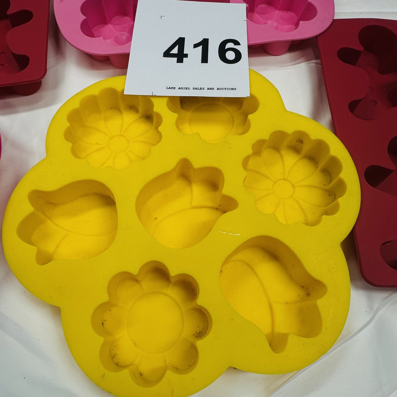 Lot 416: Wilton silicone bakeware lot: "Tulips & Daisies" flower molds, gingerbread man molds, and deviled egg trays, 7 pieces