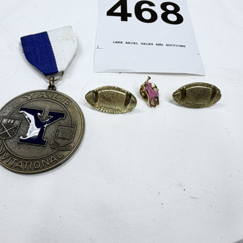 Lot 468: Yale Invitational award medal with ribbon and gold-tone football lapel pins, plus polo player pin, 4-piece lot