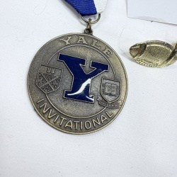 Lot 468: Yale Invitational award medal with ribbon and gold-tone football lapel pins, plus polo player pin, 4-piece lot