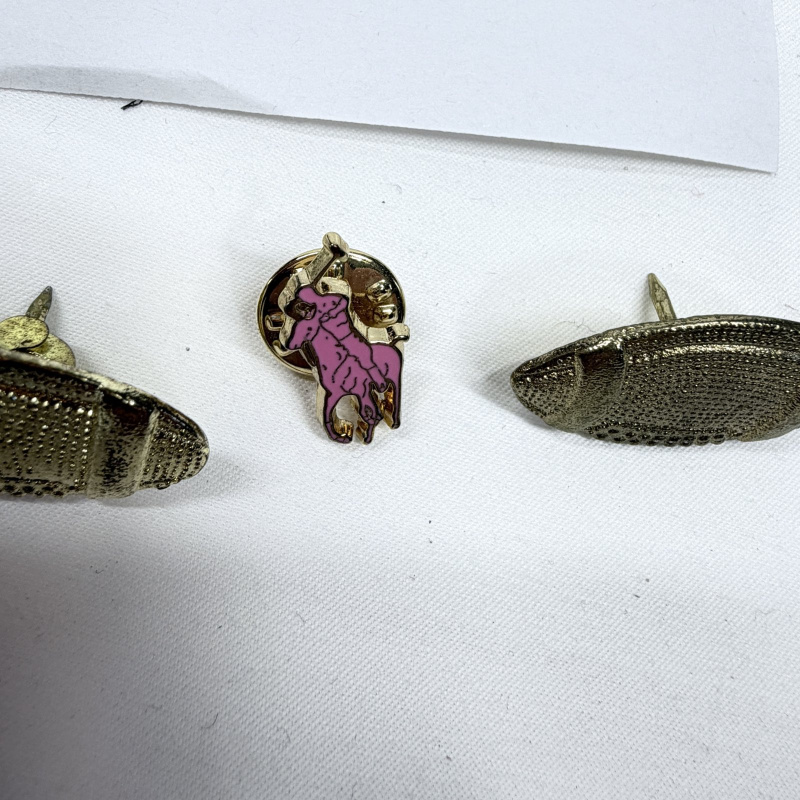 Lot 468: Yale Invitational award medal with ribbon and gold-tone football lapel pins, plus polo player pin, 4-piece lot