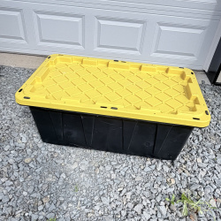Lot 653: HDX "Tough Tote" 38 gallon storage container with lid, black/yellow, made in USA