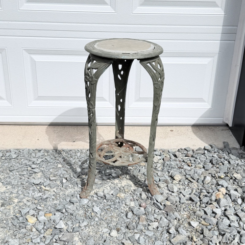 Lot 654: Vintage cast aluminum tri-leg plant stand with floral motif and stone/tile inset top, garden fern & flower design