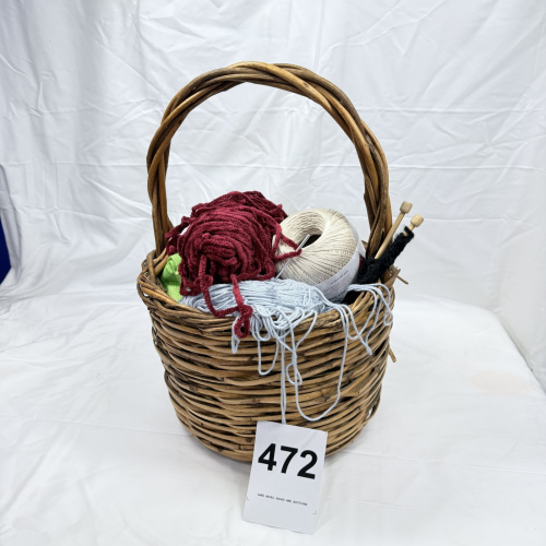 Lot 472: Wicker basket with assorted yarn skeins and pair of wooden knitting needles