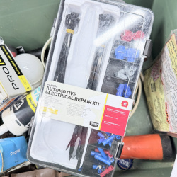 Lot 480: Mixed lot of household tools & hardware: DAP Alex Plus caulk, Secrui door/window alarm, 99-piece automotive electrical repair kit, roofing nails, LED bulb, in green storage tote