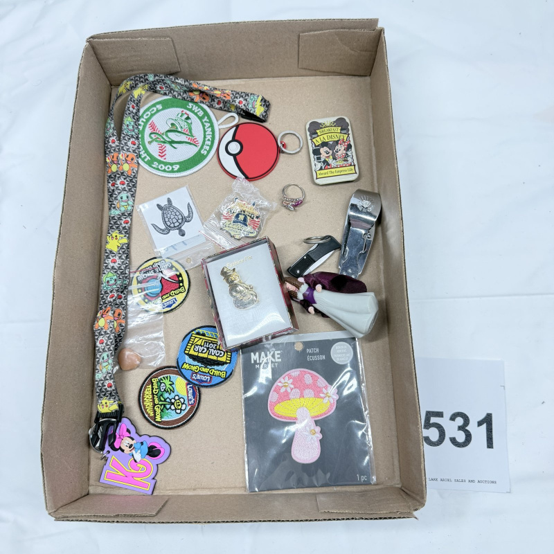 Lot 531: Mixed lot: Pokemon lanyard, SWB Yankees scout patch, Lowe's Build and Grow patches, Disney pins, costume rings, pocket knives & collectible ephemera