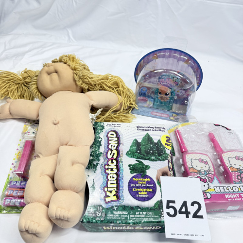 Lot 542: Toy lot: handmade Cabbage Patch-style rag doll, Hasbro Littlest Pet Shop "Sweet Life" hamster, Kinetic Sand Shimmering Emerald 2-pack, Hello Kitty Night Talkies walkie-talkies, PEZ Easter lamb dispens