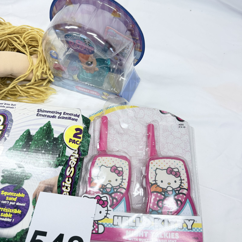 Lot 542: Toy lot: handmade Cabbage Patch-style rag doll, Hasbro Littlest Pet Shop "Sweet Life" hamster, Kinetic Sand Shimmering Emerald 2-pack, Hello Kitty Night Talkies walkie-talkies, PEZ Easter lamb dispens