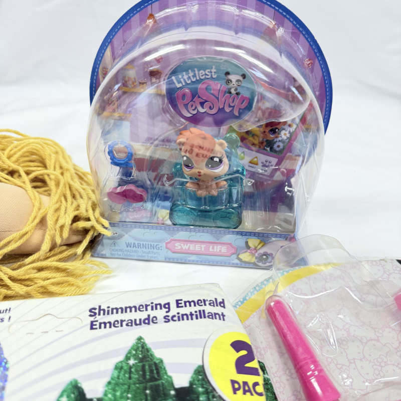 Lot 542: Toy lot: handmade Cabbage Patch-style rag doll, Hasbro Littlest Pet Shop "Sweet Life" hamster, Kinetic Sand Shimmering Emerald 2-pack, Hello Kitty Night Talkies walkie-talkies, PEZ Easter lamb dispens