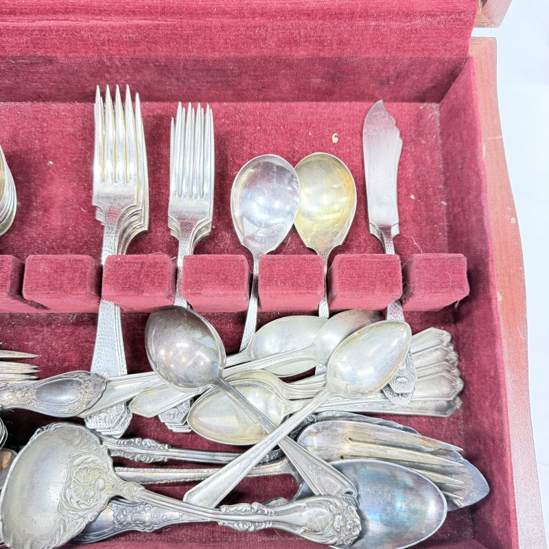 Lot 643: Vintage silverplate flatware canteen, mixed patterns, in fitted wooden chest with velvet lining, service for 12 plus extra serving pieces