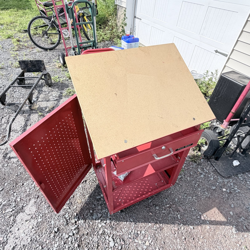 Lot 660: Test Rite rolling tool cabinet with locking drawer, pegboard door, and particle board top on casters